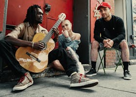 Diverse musicians perform on a city street, showcasing urban culture and friendship.