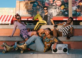 Group of young adults roller skating in a lively urban area with vibrant streetwear.